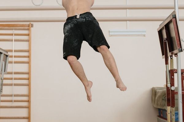 Man performing a controlled bodyweight exercise on a mat.
