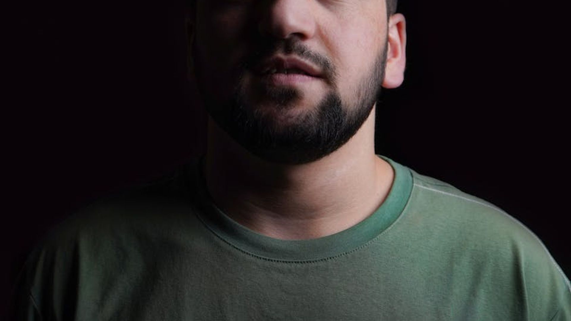Silhouette of a man in a powerful stance in a dark room.